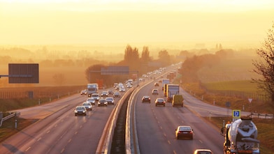 Voiture rouge circulant sur une route au bord d'une rivière
