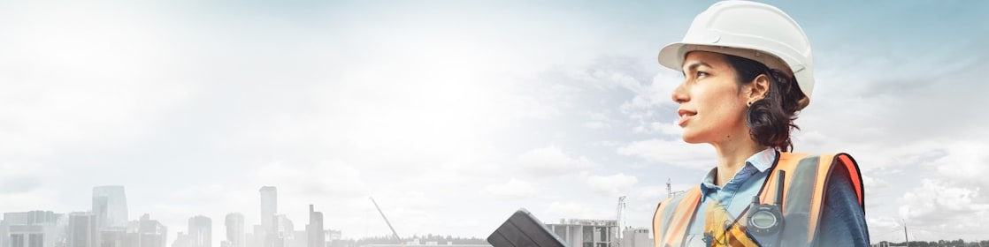 Un travailleur portant un casque jaune transposé sur un fond de route dans des montagnes