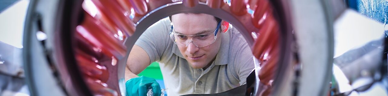 Un homme transvase des granules de plastique pour les mettre dans un malaxeur