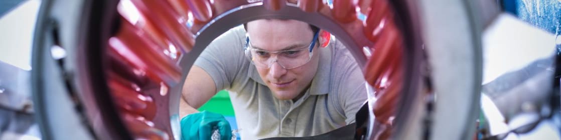 Un homme transvase des granules de plastique pour les mettre dans un malaxeur