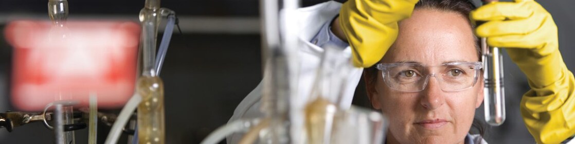femme portant des lunettes de sécurité en pleine expérience de laboratoire