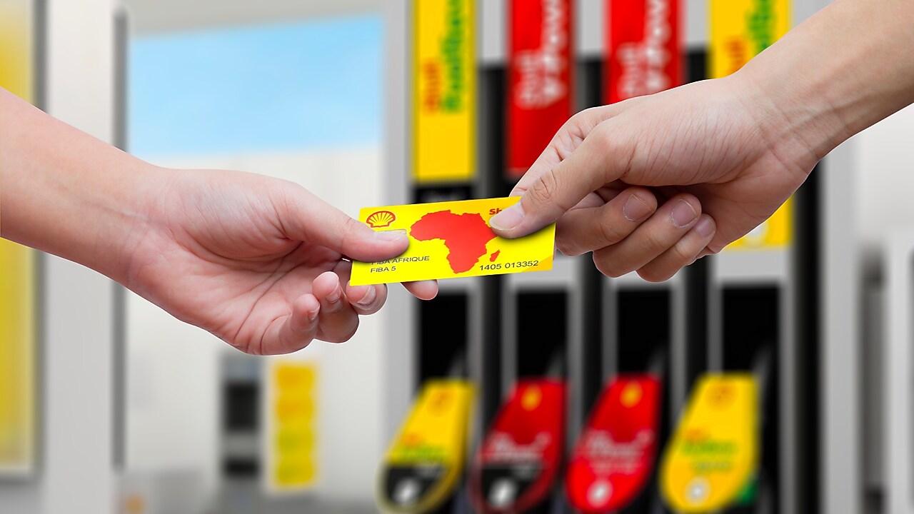 Client payant avec sa carte carburant Shell dans une station-service Shell