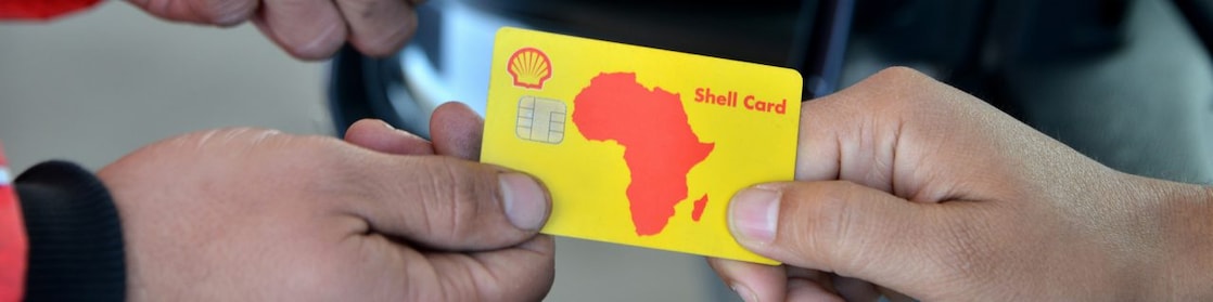 Client payant avec sa Shell Card sur un terminal tendu par un champion de service Shell