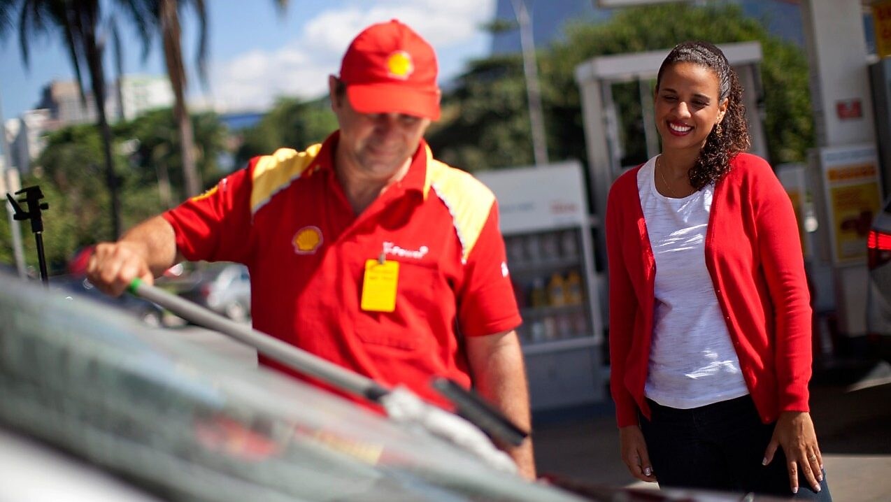 Champion de service Shell en train de nettoyer un pare-brise