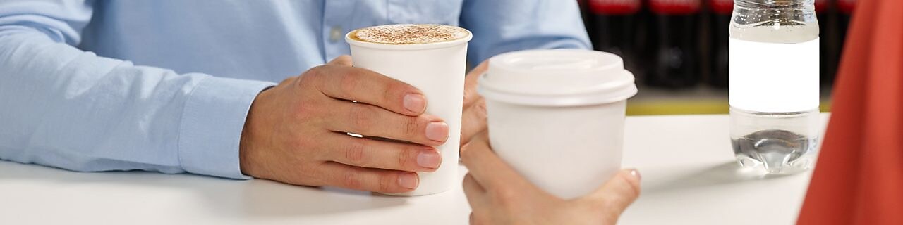 Homme souriant qui boit un café dans une station-service Shell