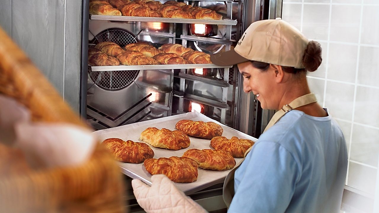 Employé Shell en train de sortir des viennoiseries du four