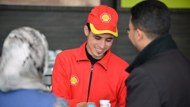 Champion de service Shell en train de servir un café à des clients