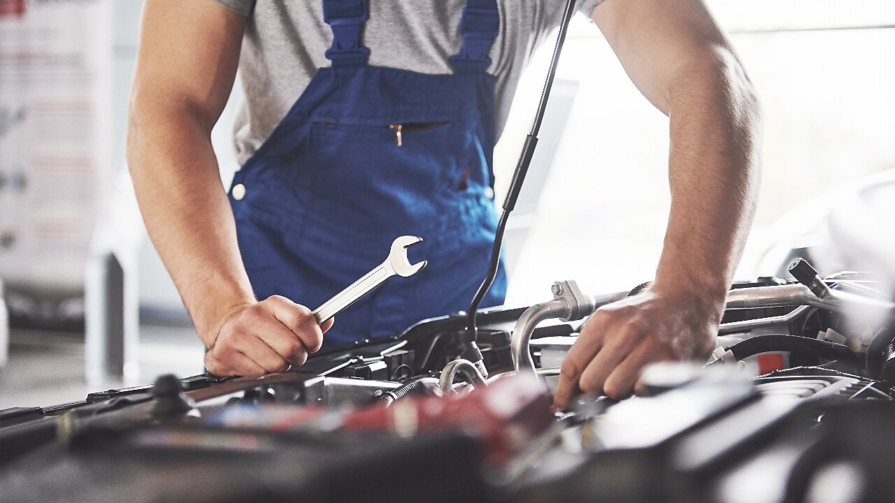 Mécanicien vérifiant le moteur d’une voiture