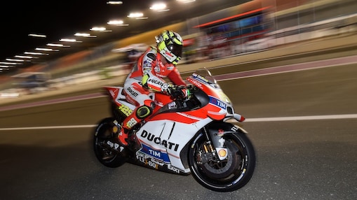 Pilote Ducati roulant vite sur une moto, sur un circuit, de nuit.