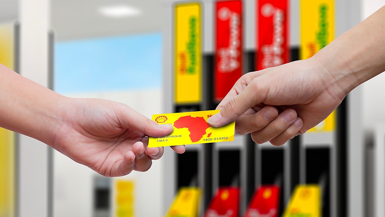 Client payant avec sa carte carburant Shell dans une station-service Shell