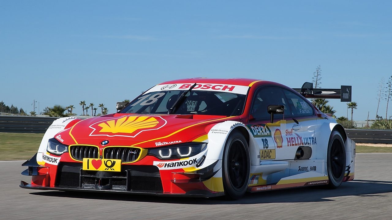 Une voiture de course BMW rouge et blanche se trouve sur la piste, illustrant le Partenariat technologique premium entre Shell Helix Ultra et BMW