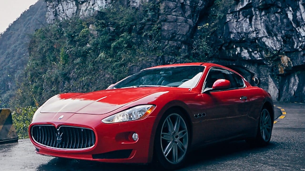 Une Maserati rouge avec le produit Shell Helix Ultra se tient fièrement sur une route de montagne pittoresque