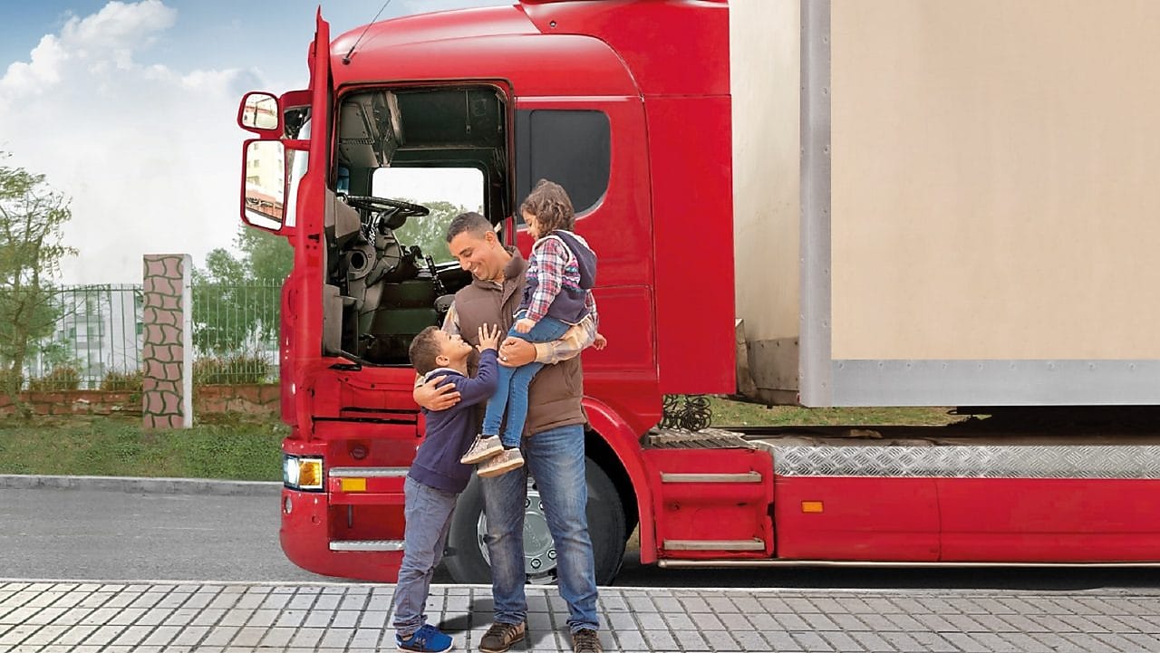 Chauffeur de camion heureux devant son engin avec ses deux enfants