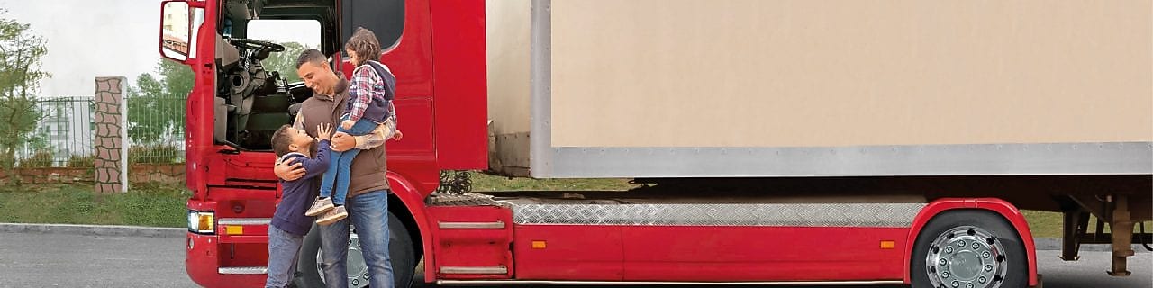 Chauffeur de camion heureux devant son engin avec ses deux enfants